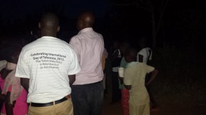 In this photo, the chairman of InterChange Uganda local chapter, Issa Kirarira, shares messages with participants including children. Next to him, on the left, John Rwabaye dons a t-shirt which reads “Celebrating International Day of Tolerance, 2013 - Play Soccer, Make Peace in Remembrance of Dr. Anne Goodman”